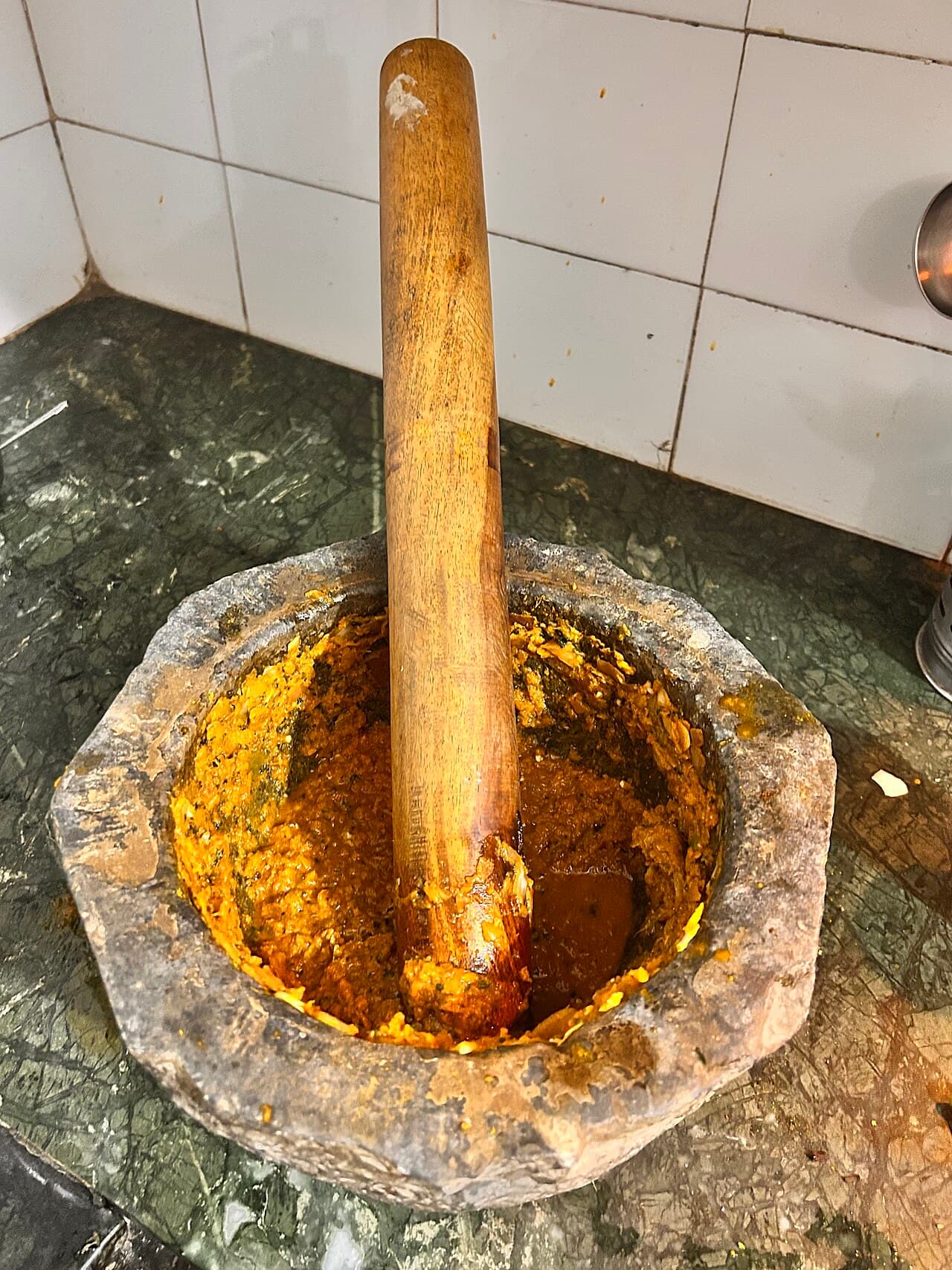 Traditional Indian kundi sota stone mortar and pestle grinding herbs